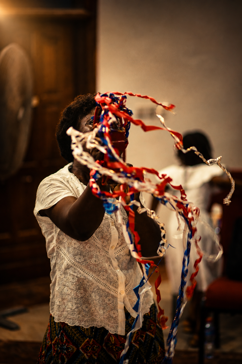 A worshipper waving red, white and blue praise ribbons